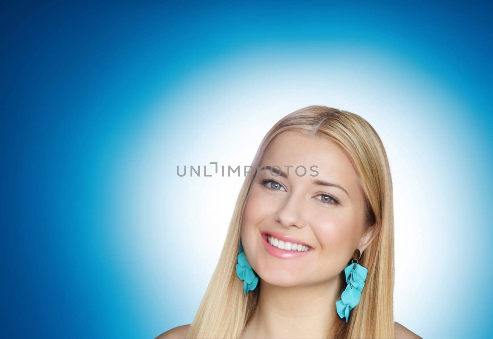 Blonde woman with radiant blue earrings, and a beaming smile, set against a vivid gradient blue background. The composition highlights her elegance and charm look