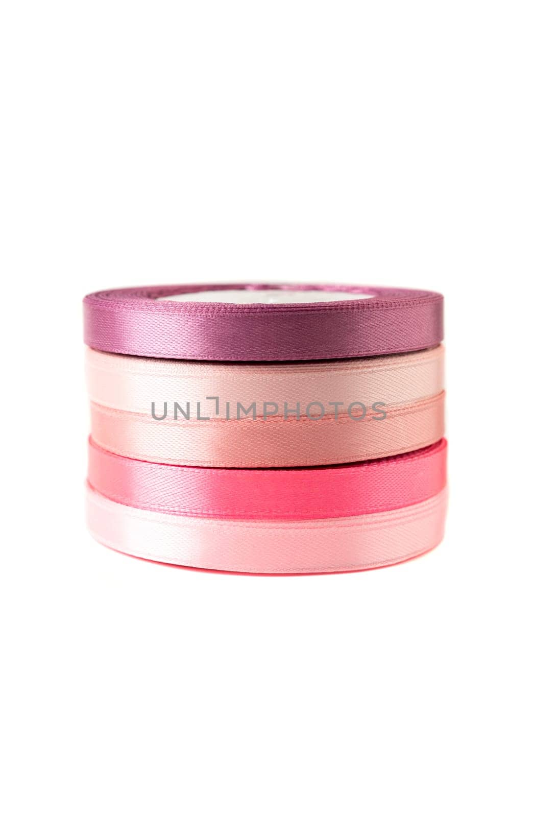 stack of satin ribbons in shades of pink against a white background