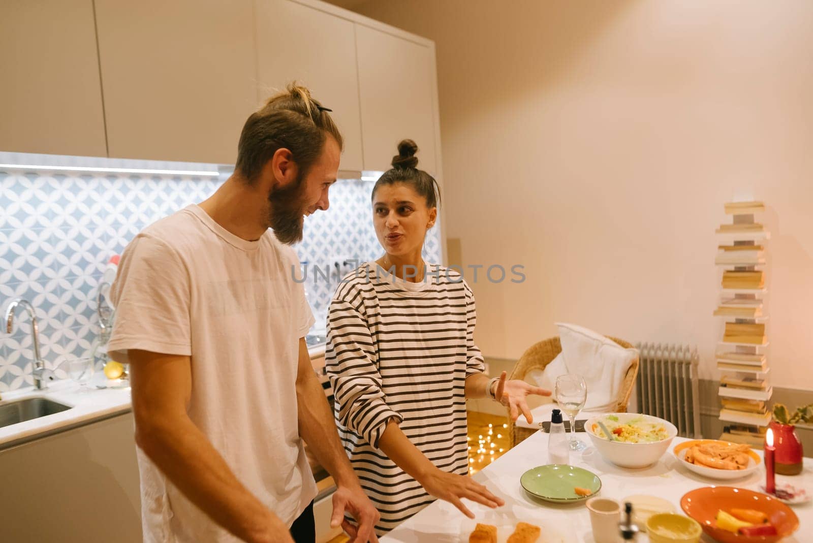 A couple joyfully cooks together in their stylish kitchen, full of fresh ingredients and a cozy vibe