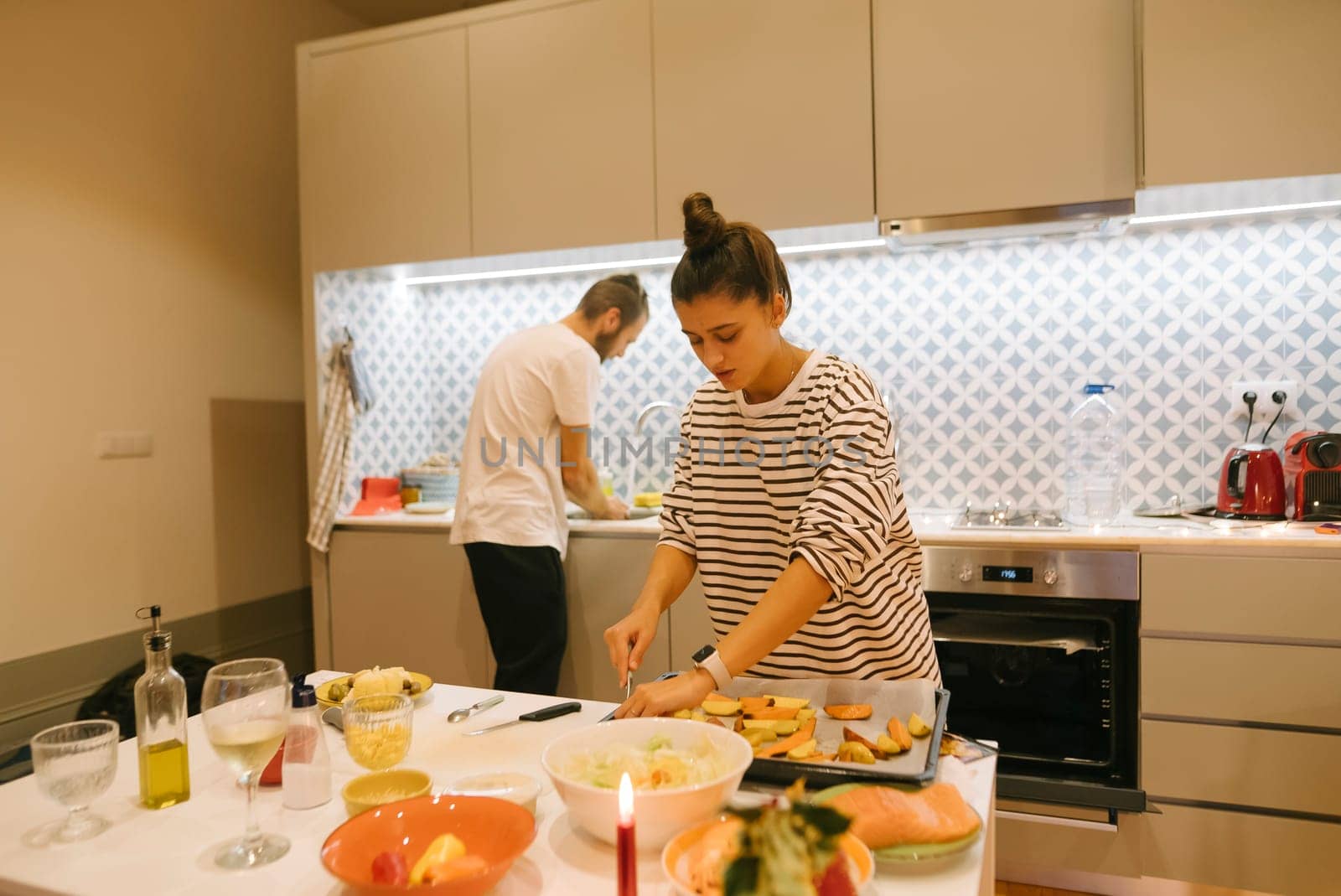 A couple happily prepares a delicious meal together, truly enjoying their quality time in a stylish kitchen