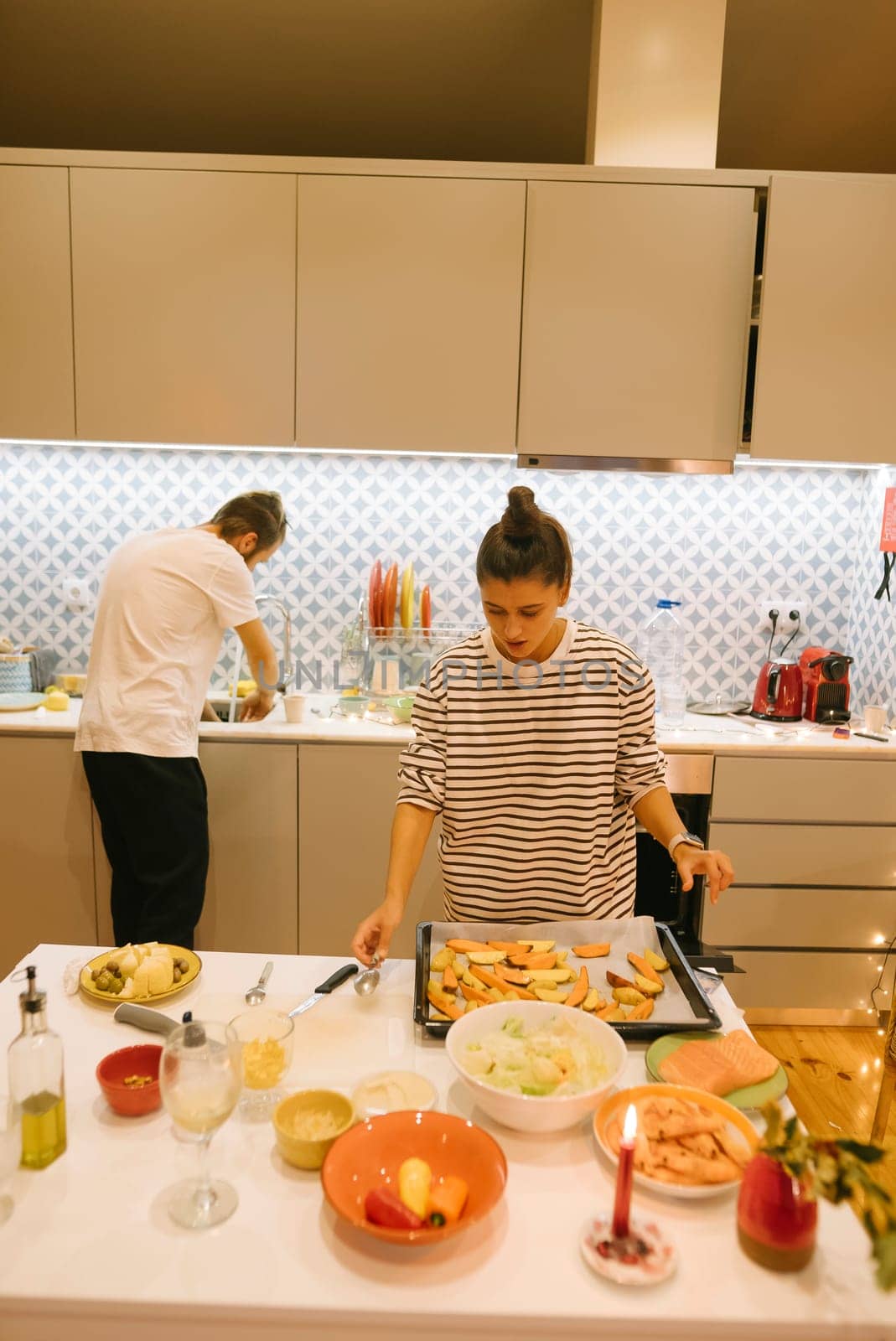 A couple collaborates to prepare a delicious meal in a stylish kitchen, showcasing their teamwork and skills