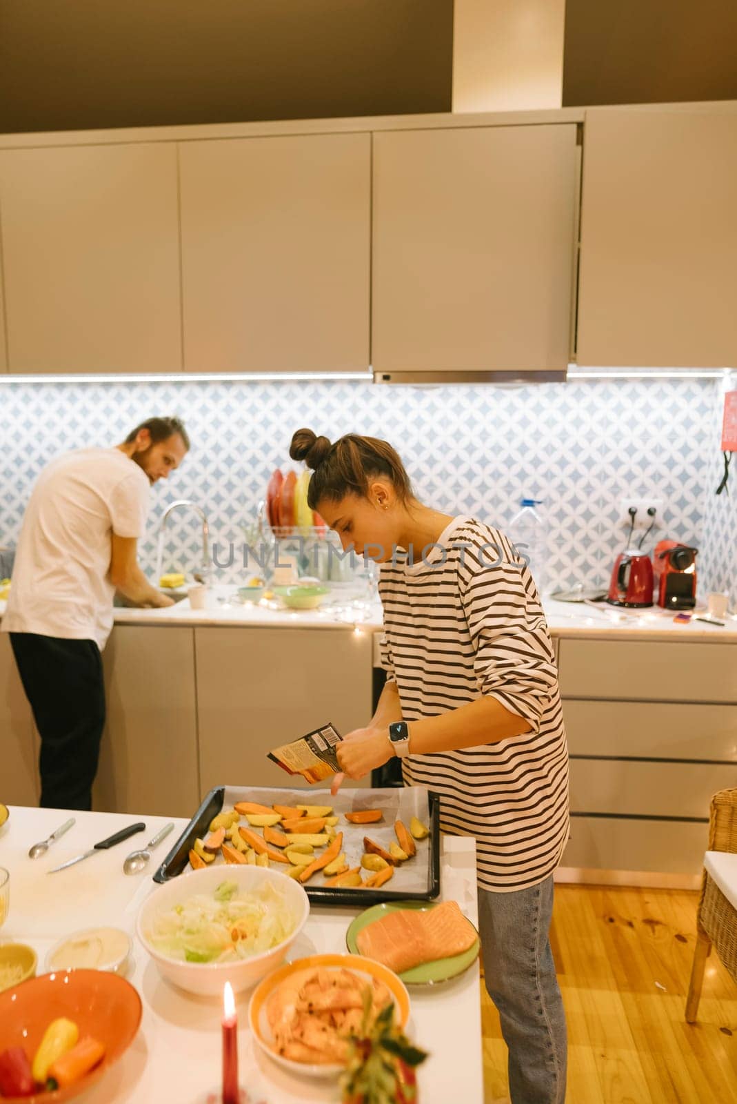 A loving couple happily enjoys cooking together in their stylish and modern kitchen, preparing delicious meals