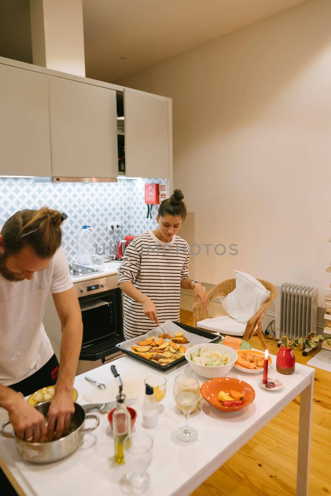 A lovely couple delights in cooking together inside a stylish kitchen that is filled with an array of fresh ingredients