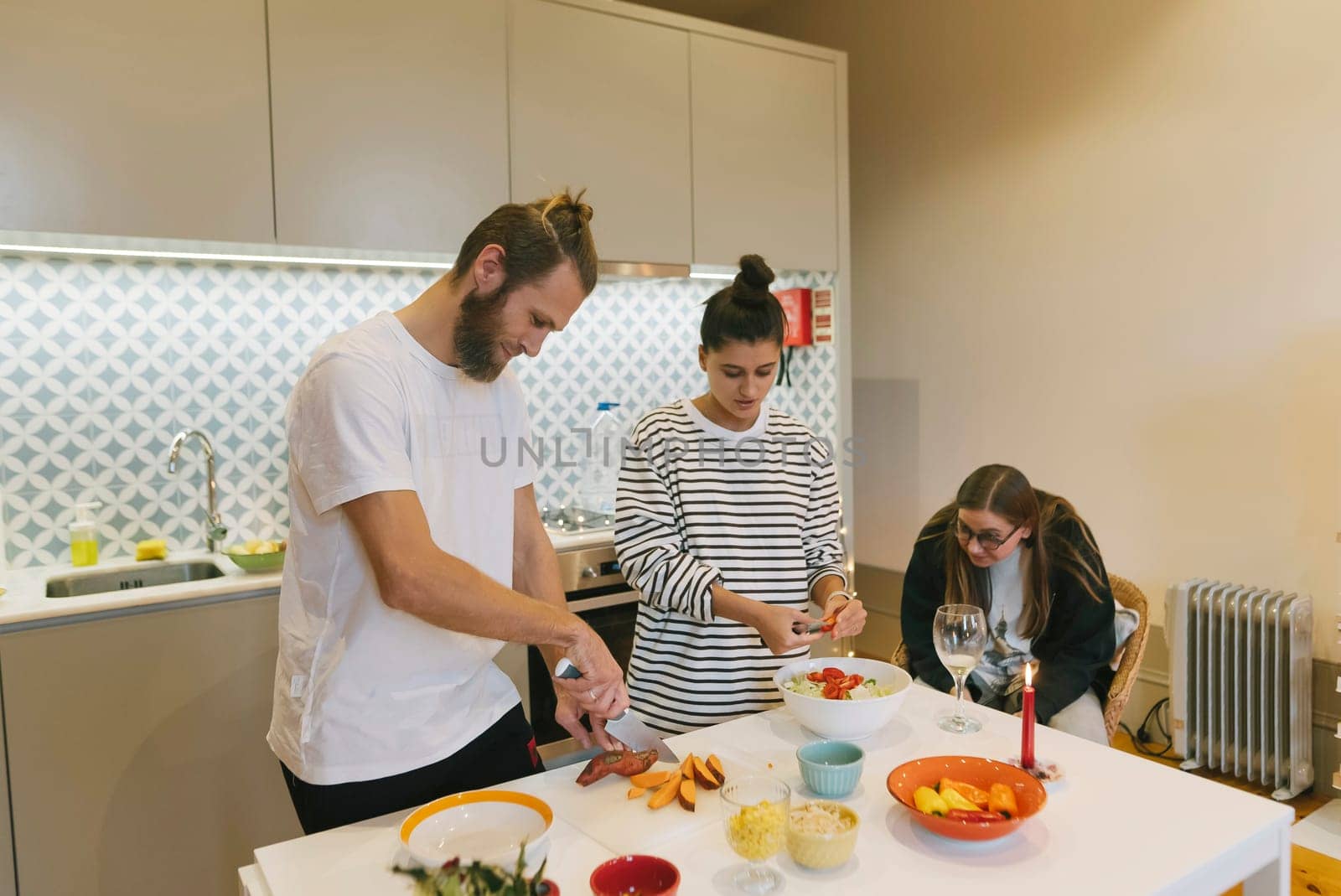 Three close friends share the joy of cooking delicious meals together in a bright and inviting kitchen space