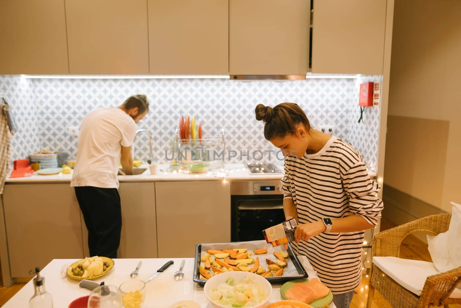 A couple collaborates harmoniously in a stylish modern kitchen as they prepare delicious and healthy meals together