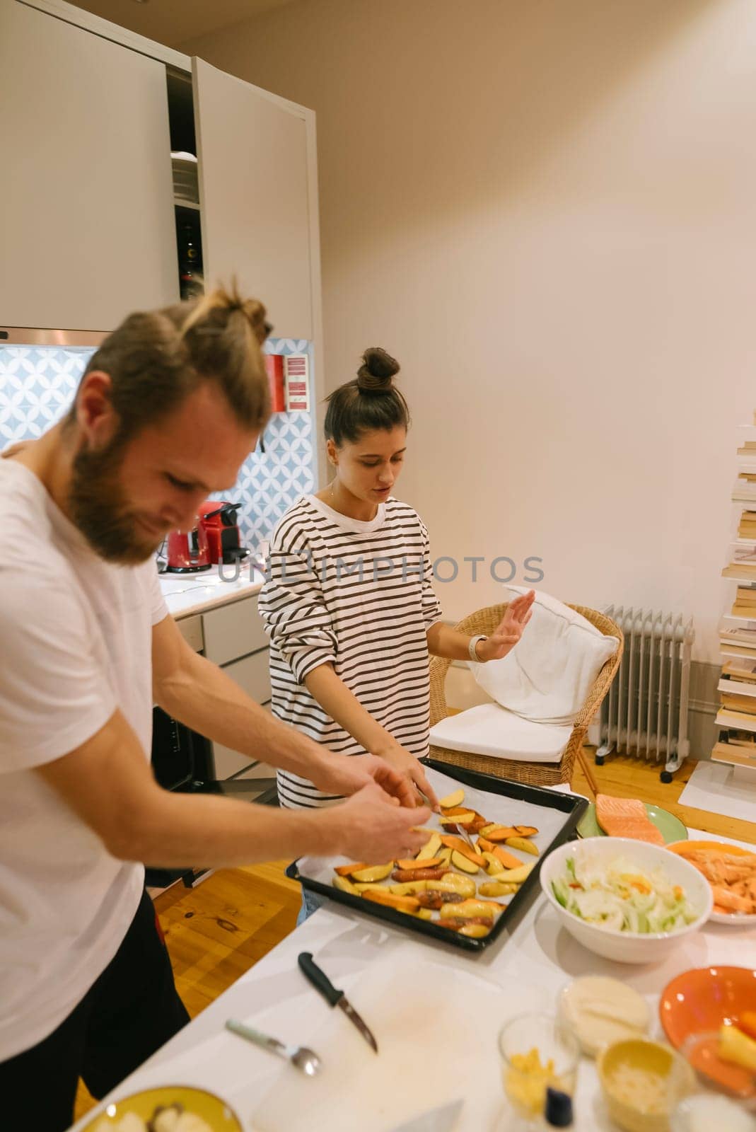 A couple joyfully prepares a delicious meal together in a bright and inviting kitchen setting, filled with warmth