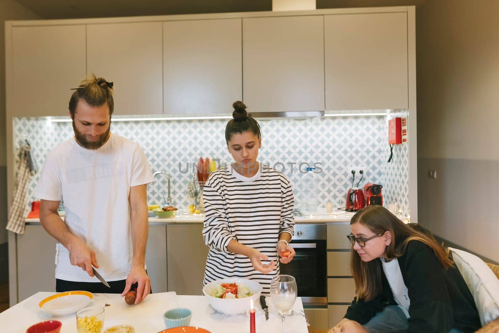 Three friends gather in a stylish kitchen to prepare a meal together, enjoying quality time and creativity