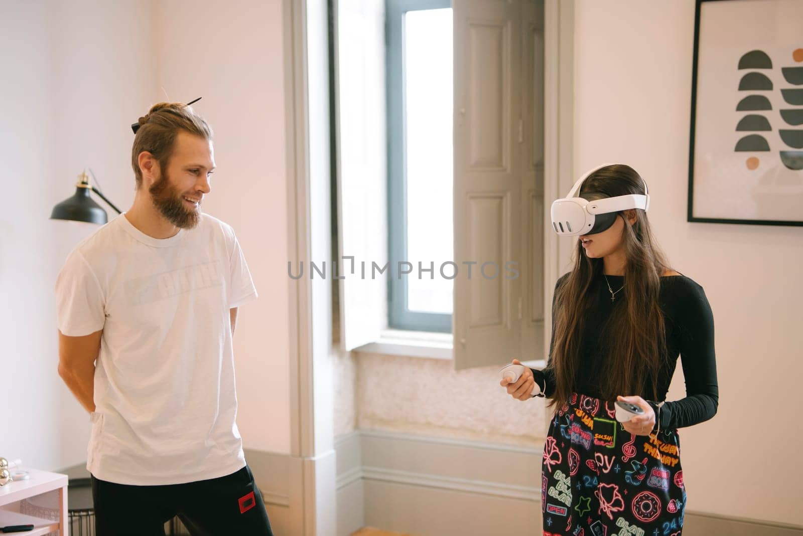 A couple happily explores the world of virtual reality together in a stylish and contemporary living space