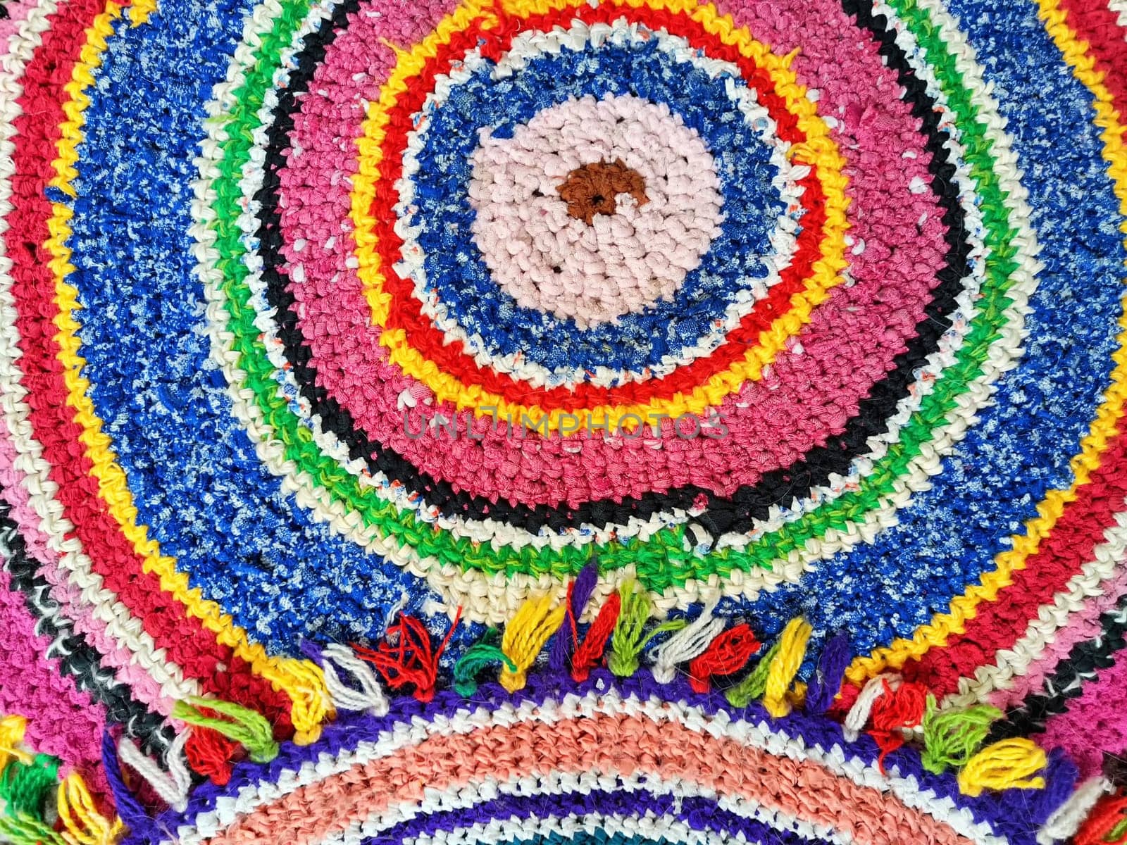 Detailed crochet artwork showcasing a circular design in bright colors, perfect for adding a pop of color and texture to any setting.