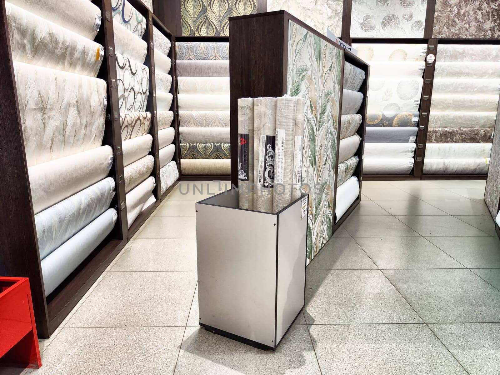Kirov, Russia - August 08, 2023 - Customers can explore a variety of wallpaper rolls displayed on shelves to choose the perfect design for their spaces.