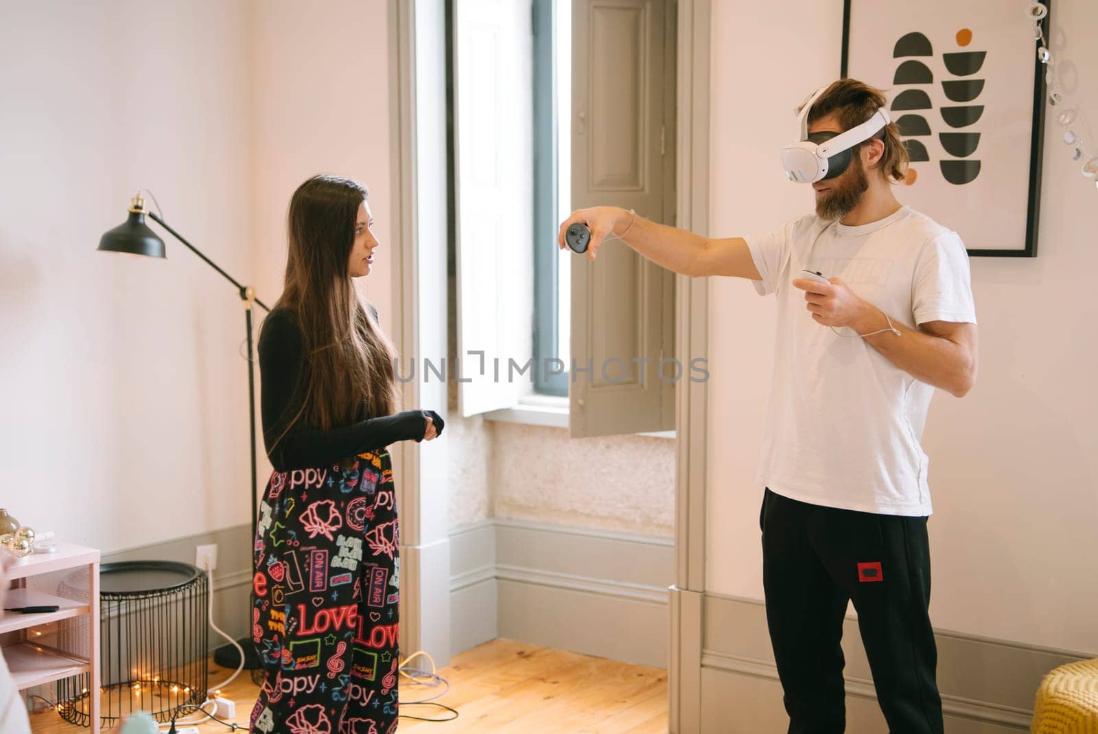 An engaging and immersive virtual reality experience shared between two individuals in a stylish, modern room