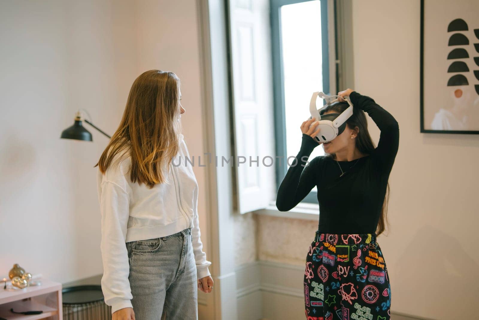 Two women explore virtual reality in a modern room, beautifully showcasing technology and friendship