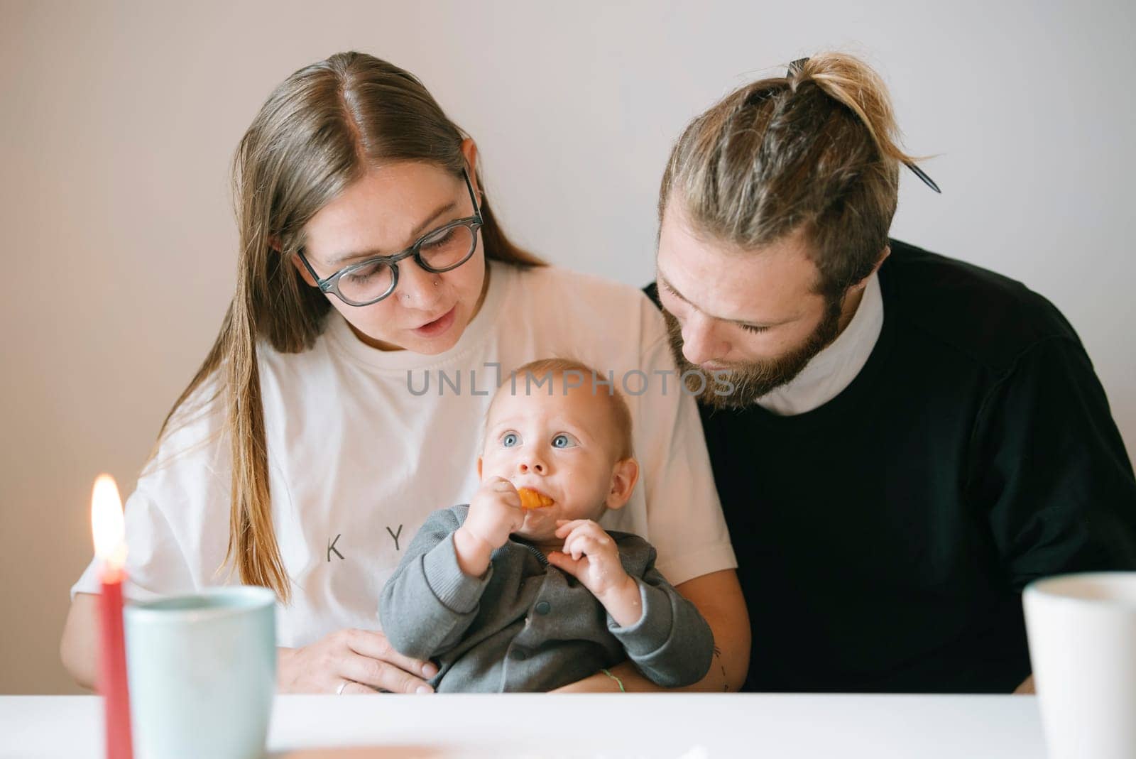 A heartwarming and cozy family moment where loving parents provide tender care for their adorable baby at home