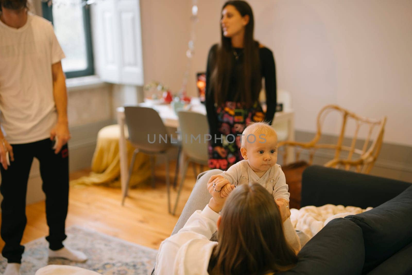 A heartwarming and delightful scene capturing beautiful family bonding with an adorable baby in a stylish living room