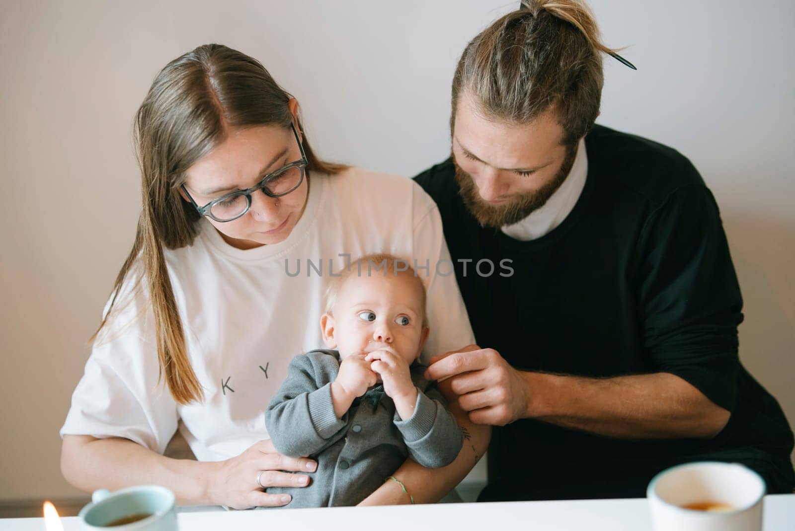A loving and caring couple joyfully spending precious quality time with their adorable baby at home together