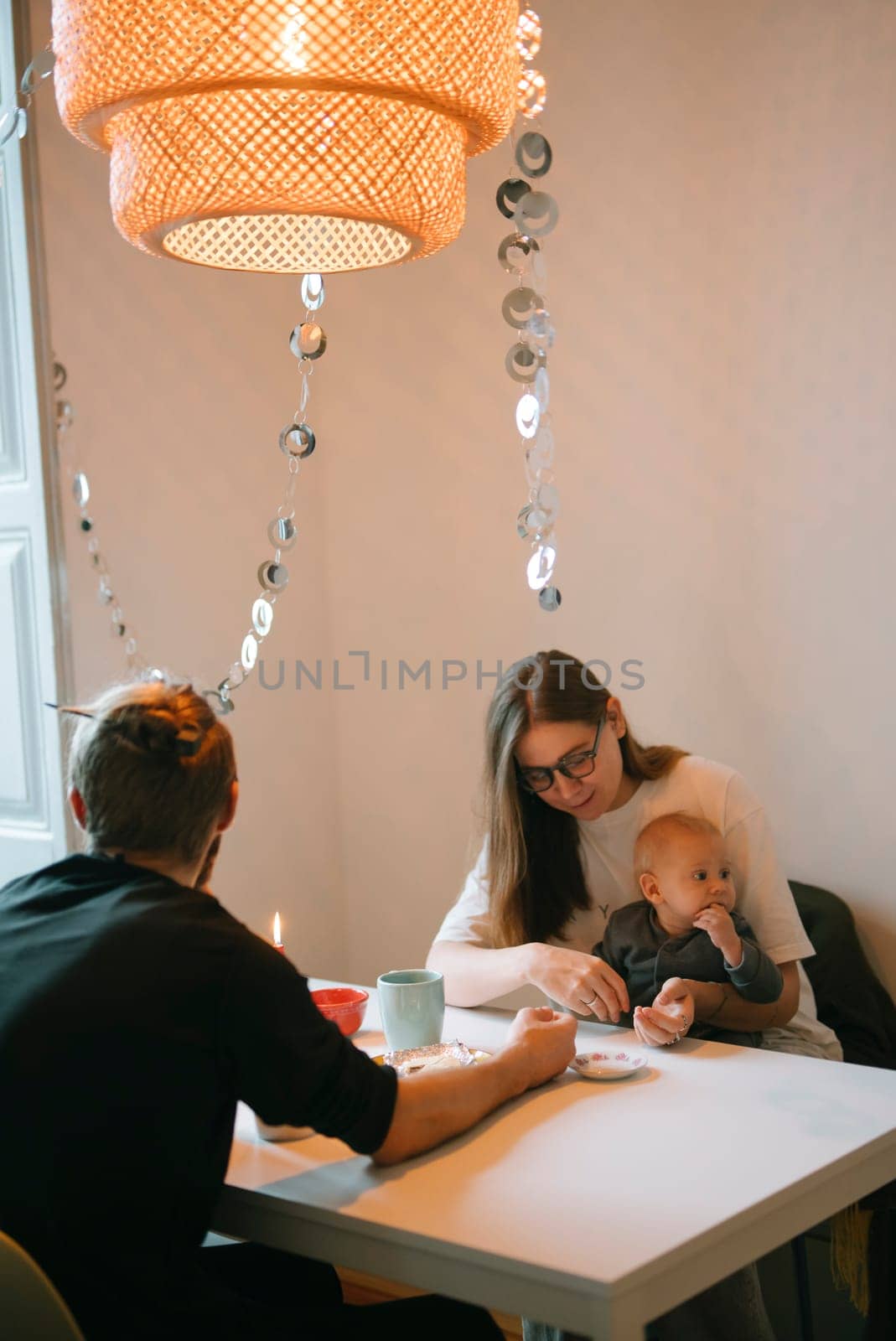 A warm and inviting family scene featuring a parent enjoying time with a baby in a cozy dining setting together