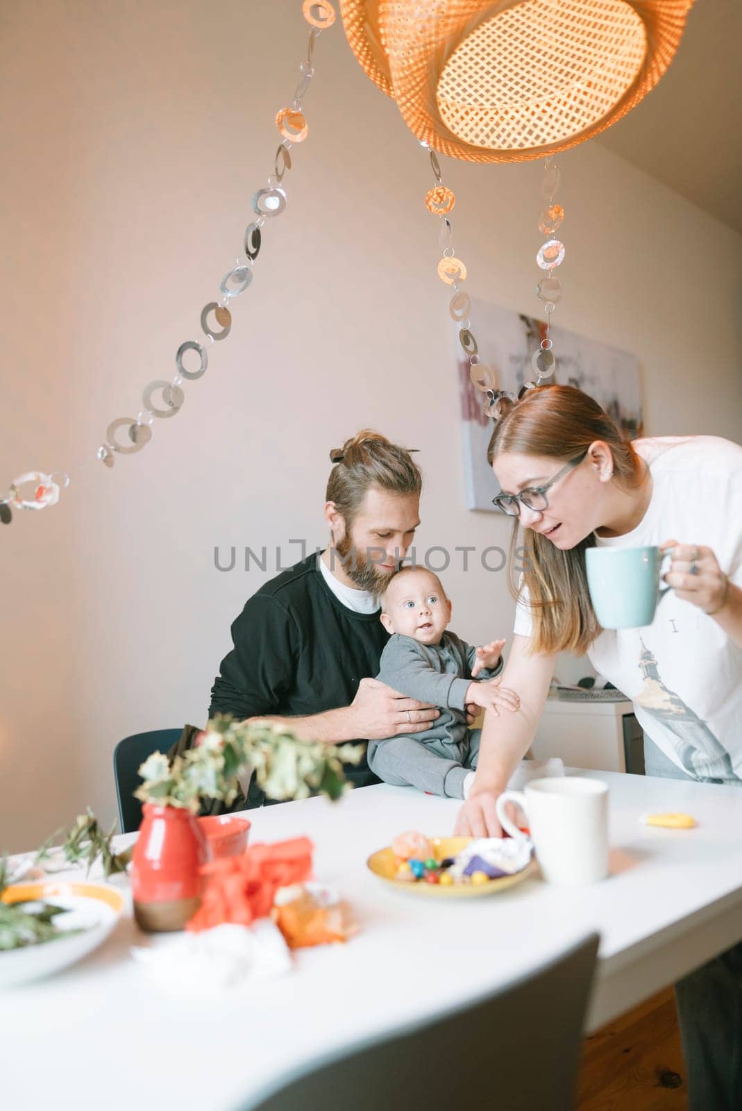 A truly joyful family moment together at home, sharing delicious food and heartfelt laughter with their baby