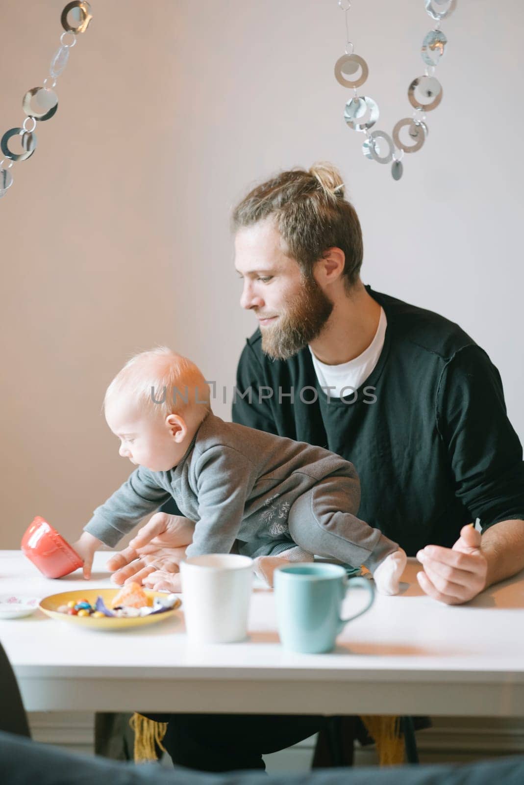 A heartwarming and delightful scene of a loving father interacting affectionately with his baby during breakfast time