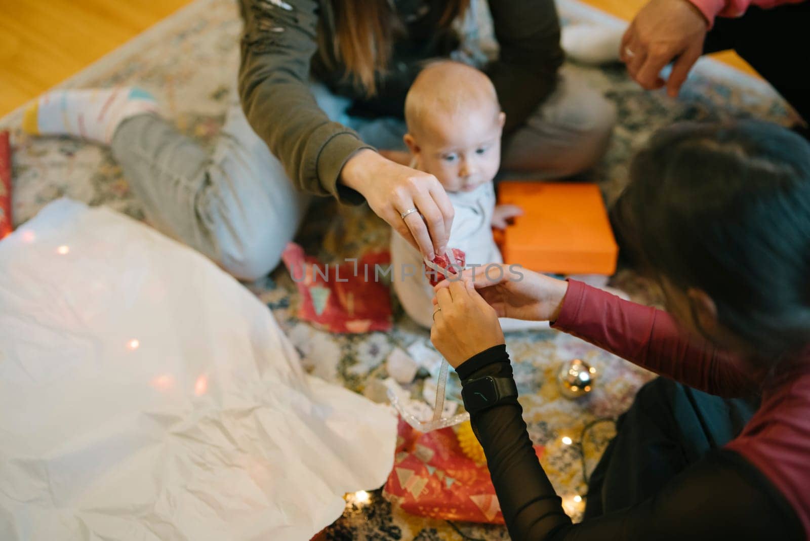 A delightful family moment, capturing the holiday excitement shared with an adorable baby and colorful, festive gifts
