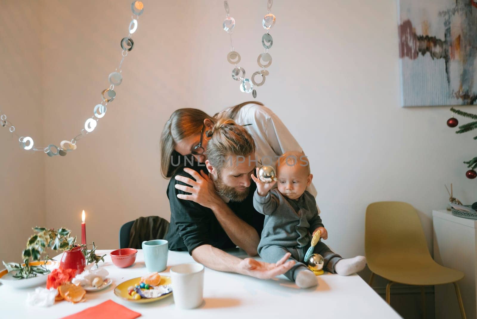 A heartwarming family moment gathered around the dining table, joyfully celebrating together with a cheerful baby