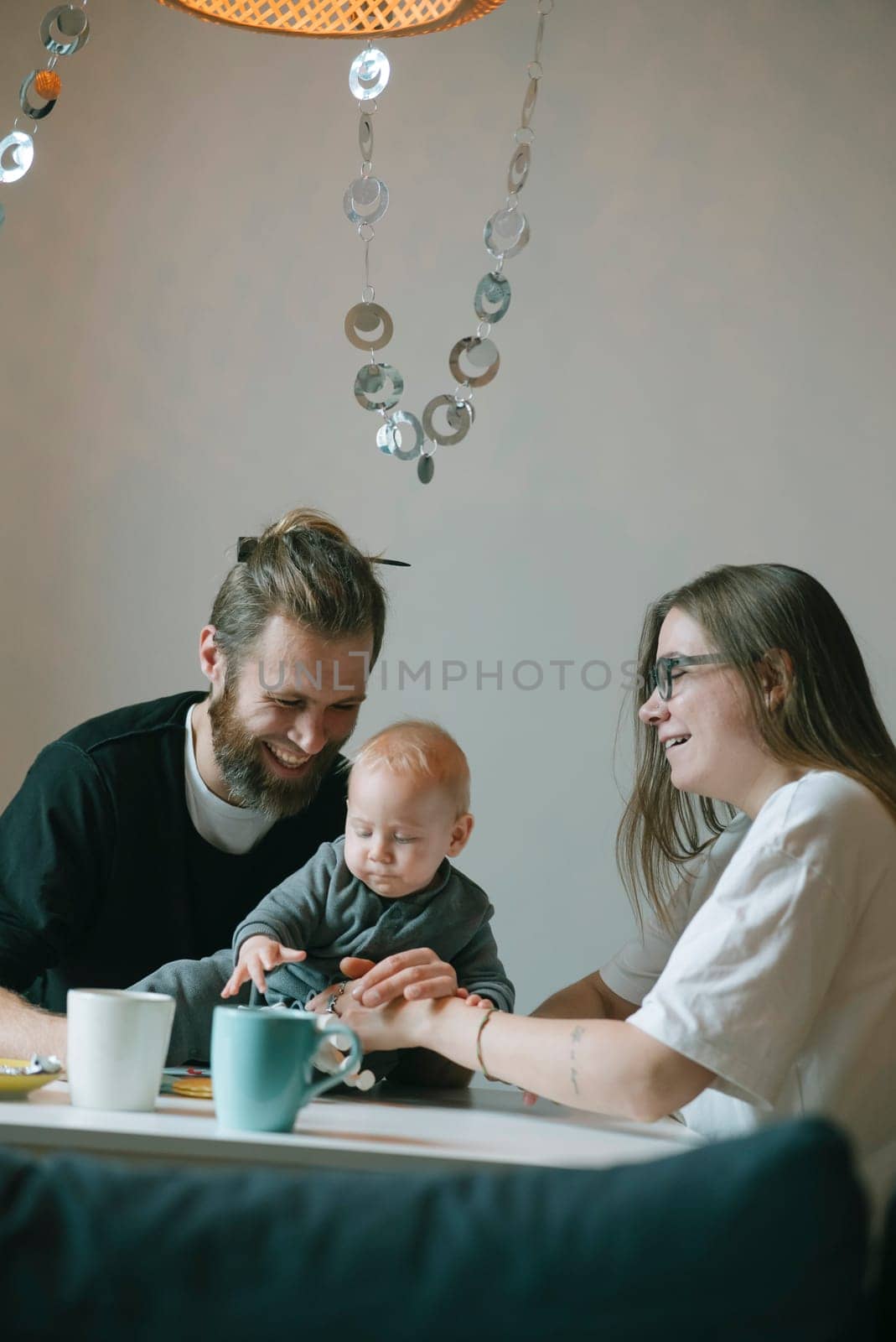 A joyful family happily sharing playful and heartwarming moments with their baby in a cozy home setting