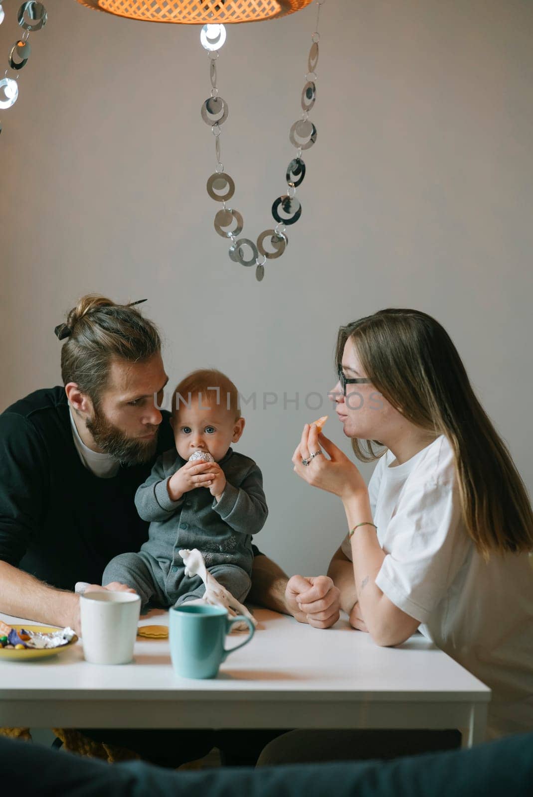 A truly heartwarming family moment with loving parents and their adorable baby enjoying delicious snacks together