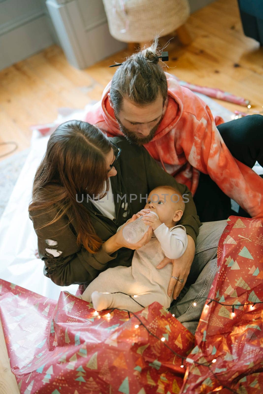 A truly heartwarming scene of a loving family caring for their adorable baby among vibrant festive decorations