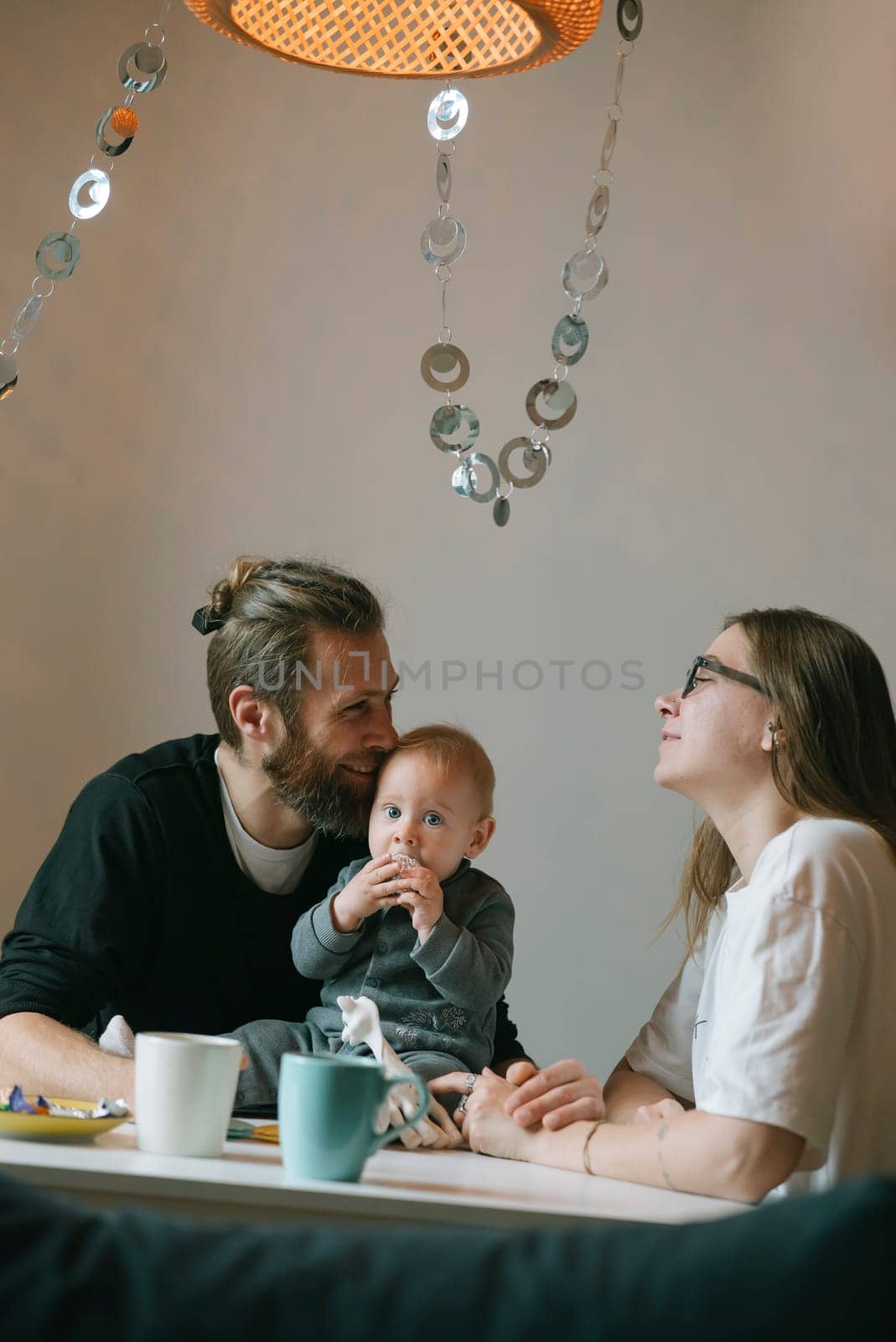 A loving family enjoys a playful moment at home with their adorable baby, creating cherished memories