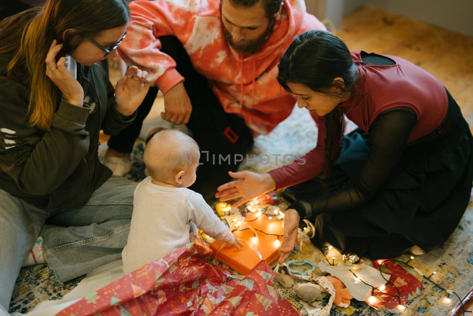 A wonderful and warm family moment featuring a sweet baby joyfully interacting with colorful lights and loved ones