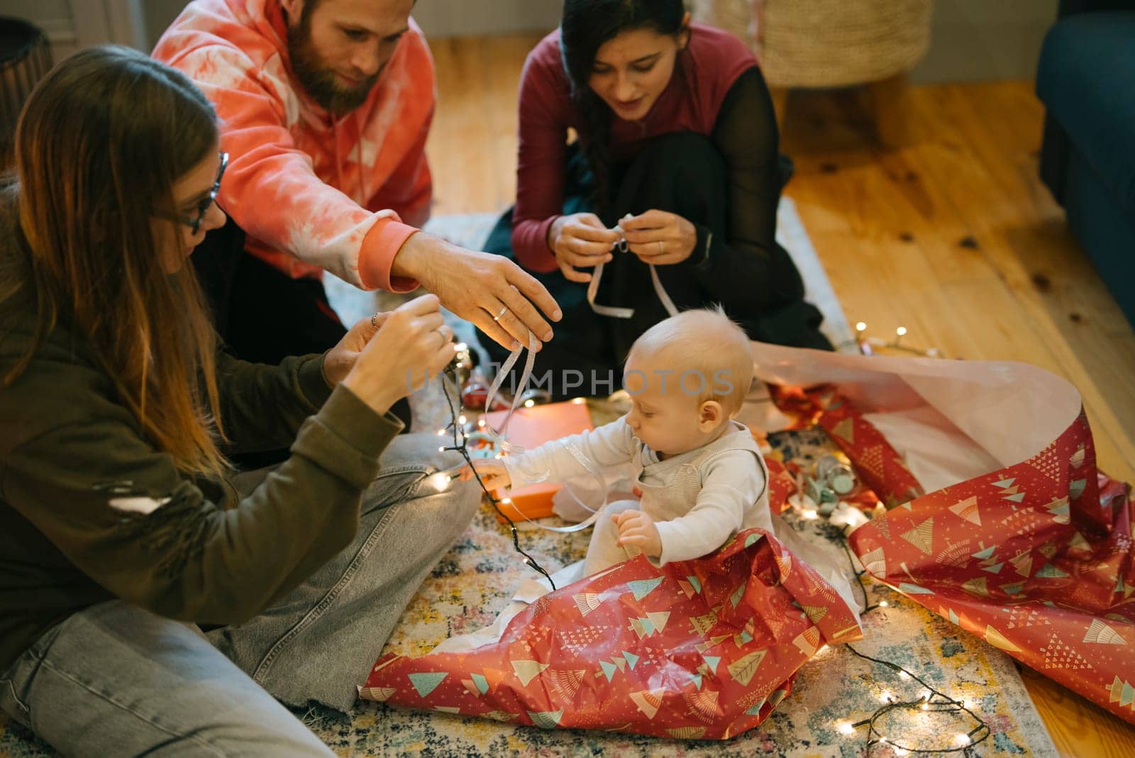 A joyful family moment with a baby amidst vibrant holiday decorations and bright lights creating cheer
