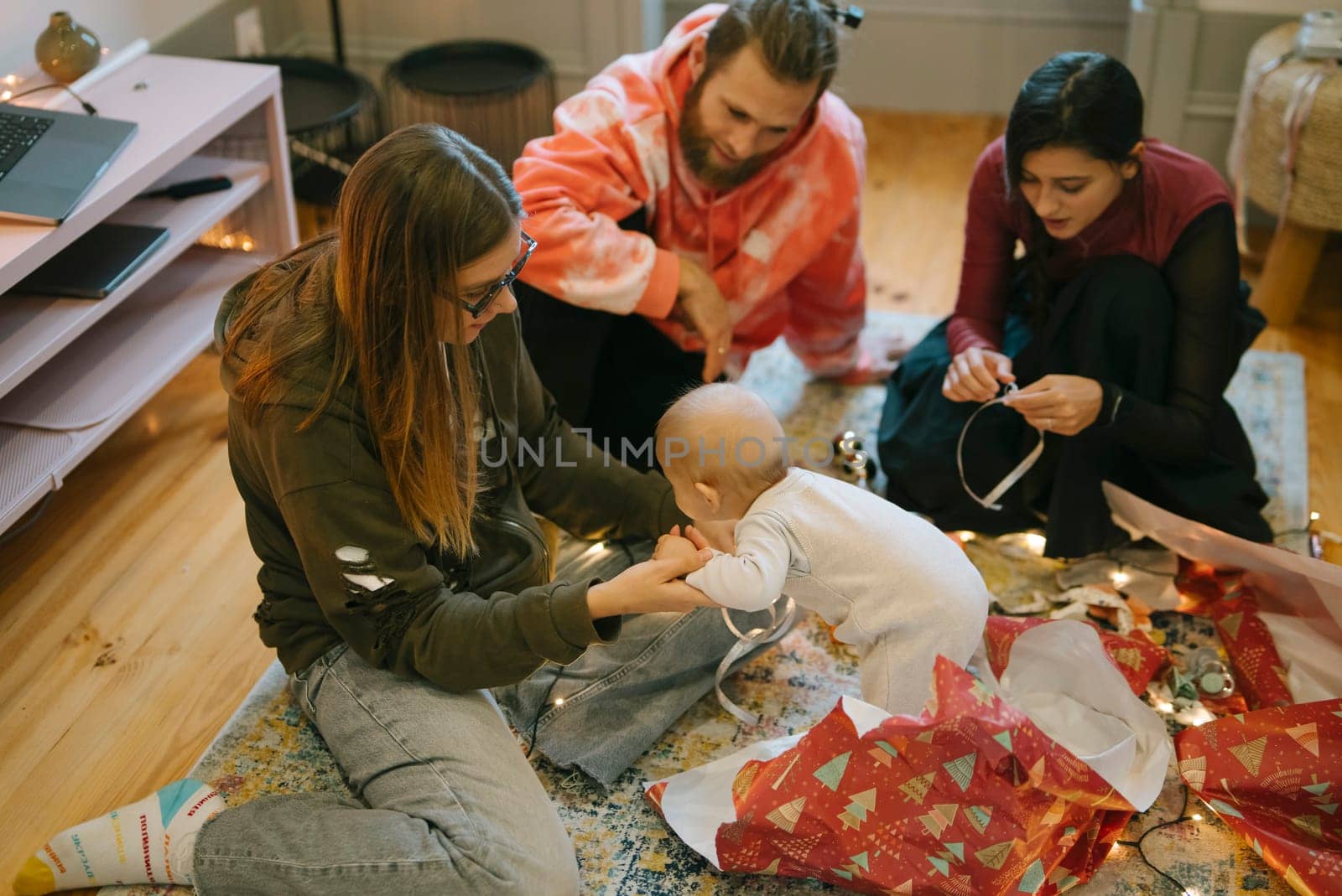 A joyful family moment captured during the holidays, featuring a cheerful baby with festive decorations