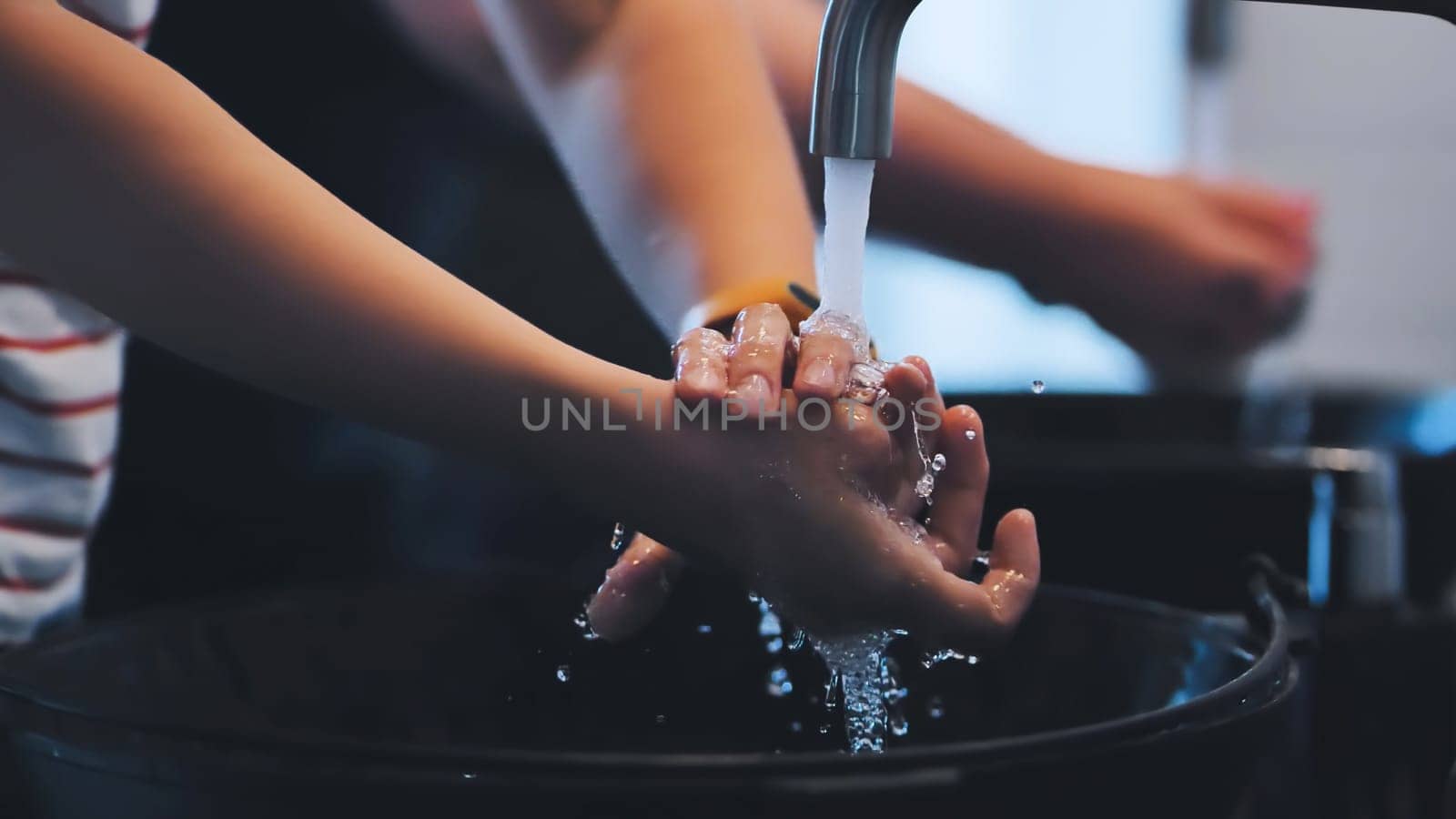 Kids are carefully washing their hands with soap and water in a sink, promoting hygiene and preventing the spread of germs