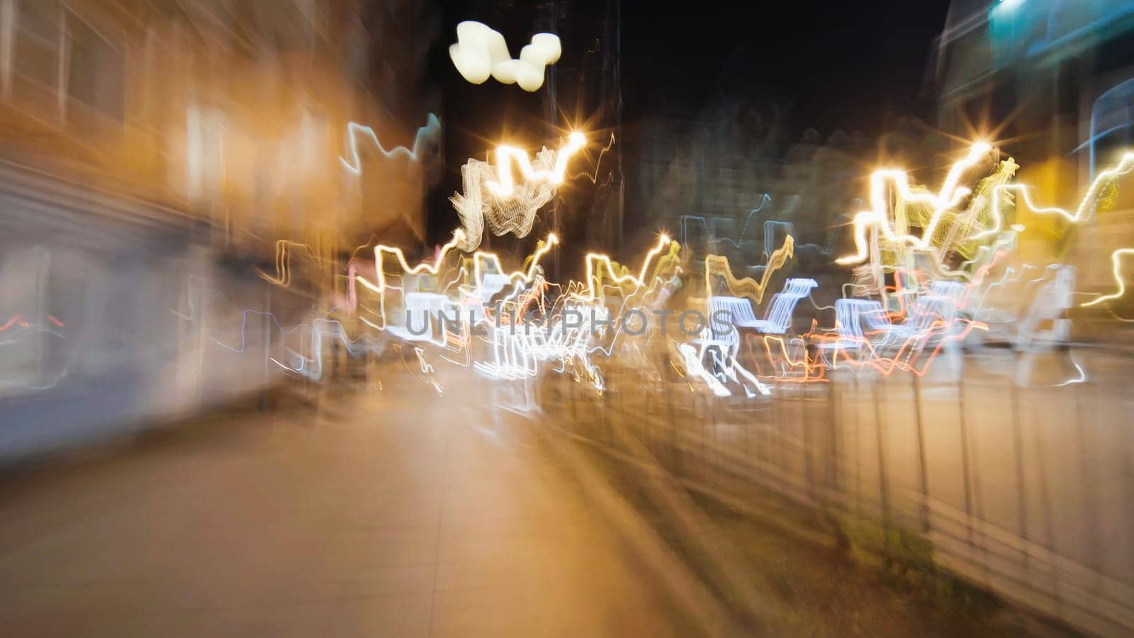 Light trails creating dynamic patterns through a city street at night, capturing the energy of urban life