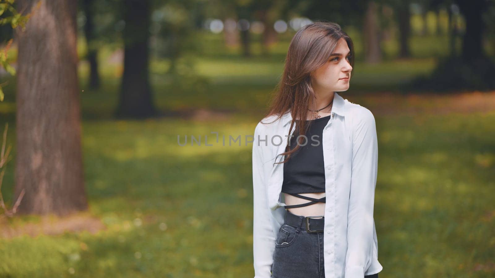 Young georgian woman enjoying the tranquility of a green park, surrounded by trees and grass, embracing the peaceful atmosphere of nature