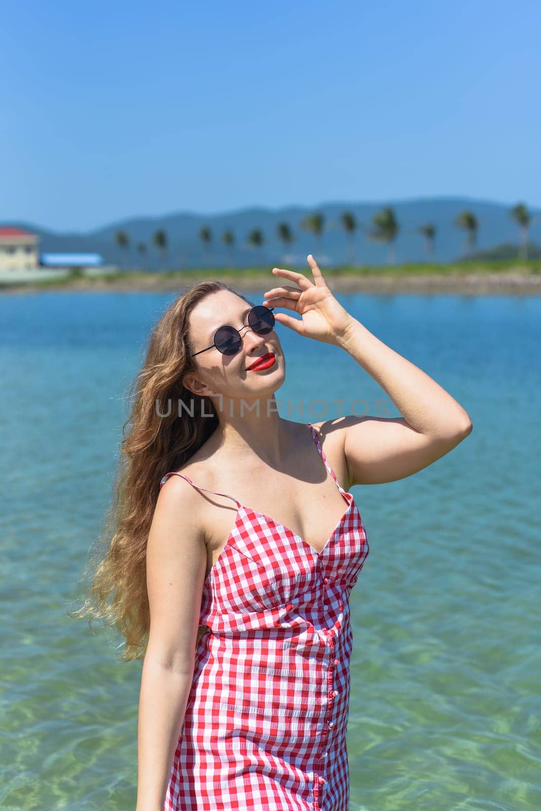 Bright blond young woman standing in sea in summer