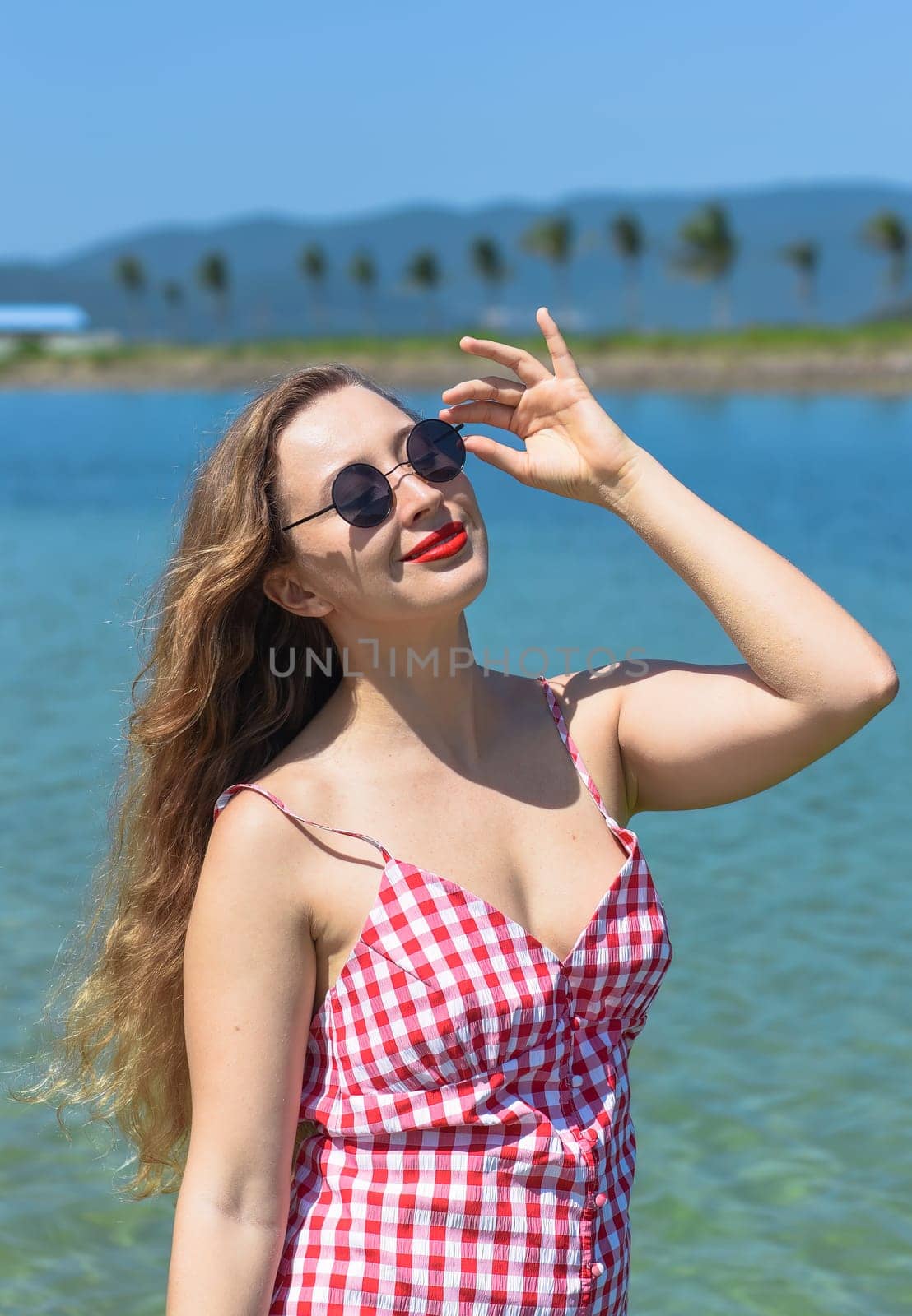 Bright blond young woman standing in sea in summer