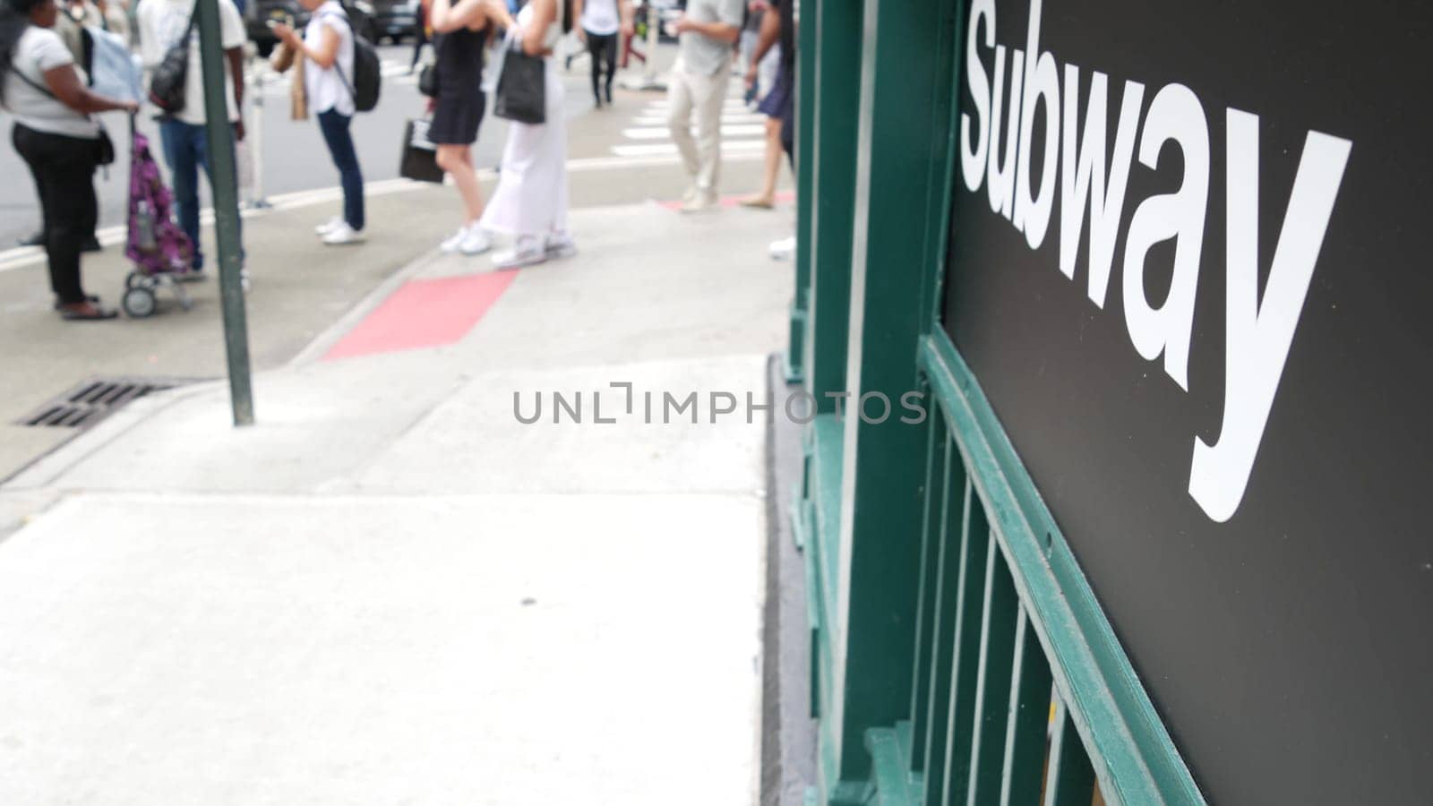 New York City, United States - 29 Aug 2023: Subway sign, underground metro station. Metropolitan entrance fence, public passenger transport exit, text signboard. Pedestrians people on Manhattan street