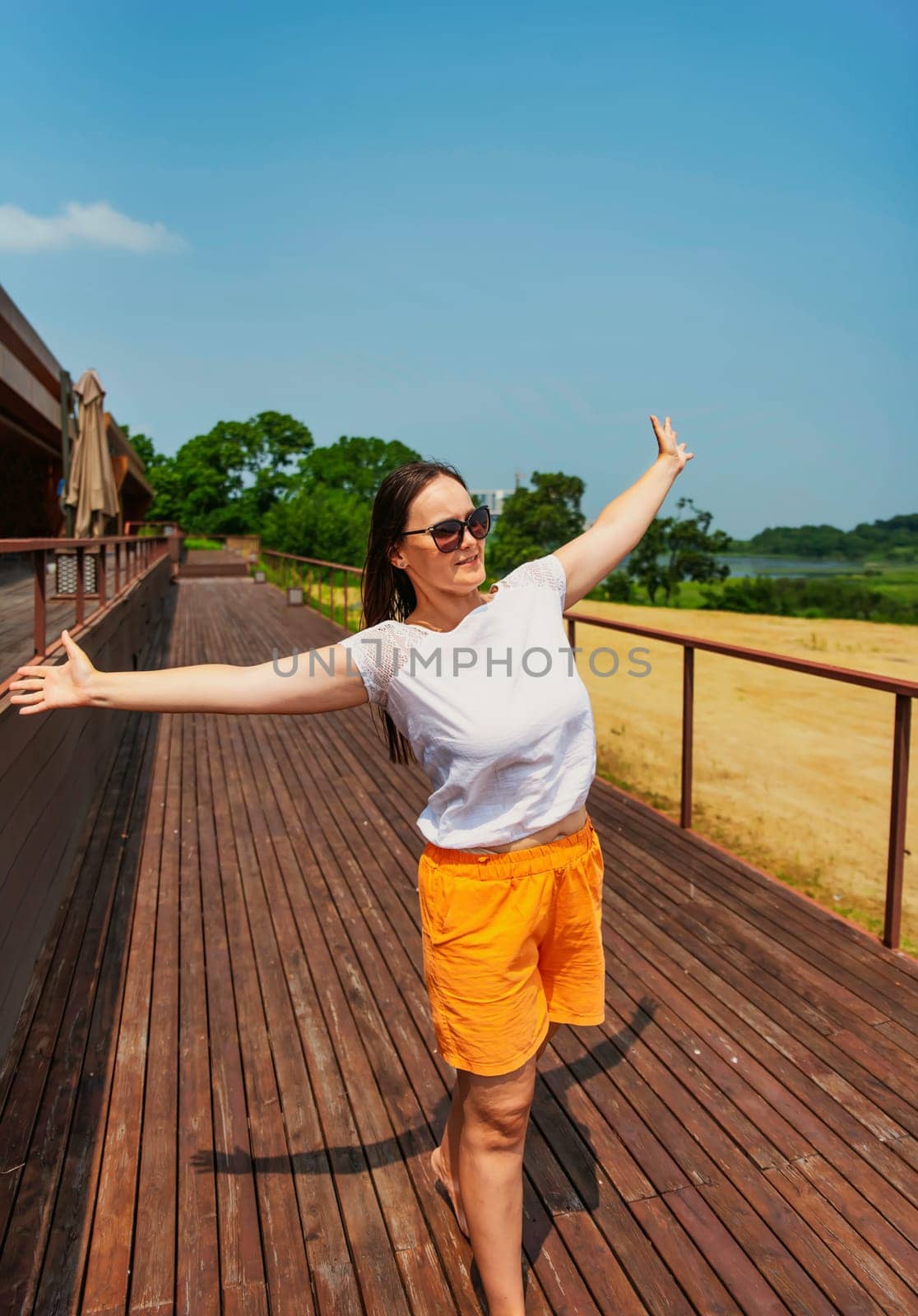 36 years old russian woman in orange shorts and sunglasses enjoying the summer day