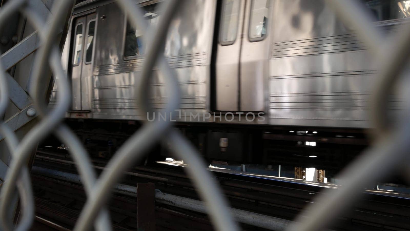 New York City, United States - 14 Sept 2023: Manhattan Bridge to Brooklyn Dumbo. American subway metro train from pedestrian path. Public railway transport. Railroad traffic and architecture in USA.
