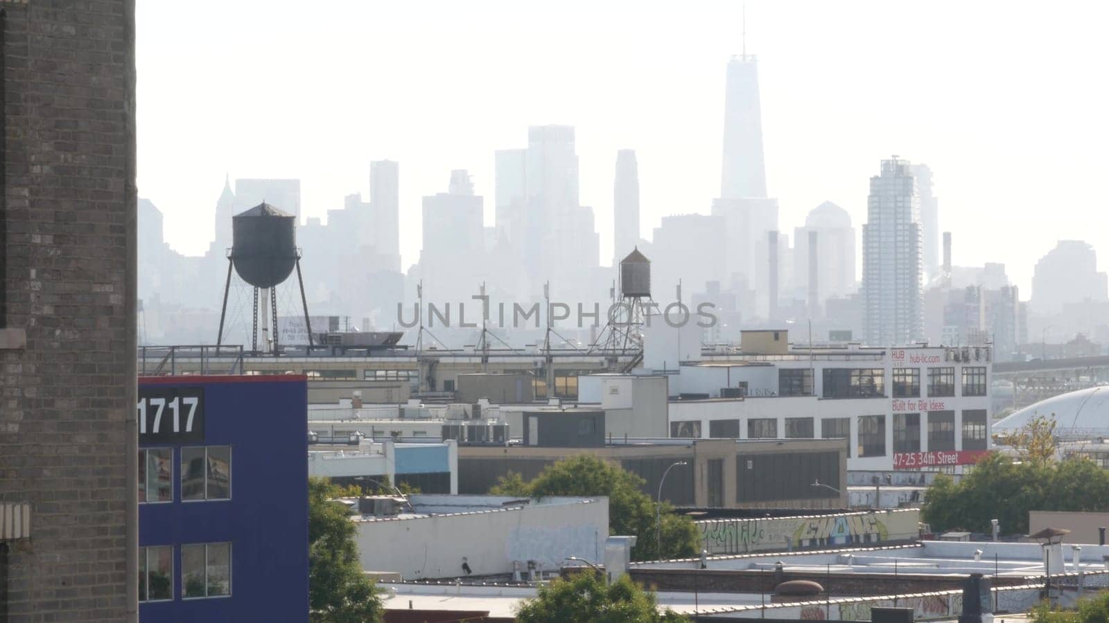 New York City, United States - 3 Sept 2023: Manhattan downtown financial district skyline cityscape. World Trade Center skyscraper. Rooftop water tower, tank on roof. Industrial buildings in Queens.
