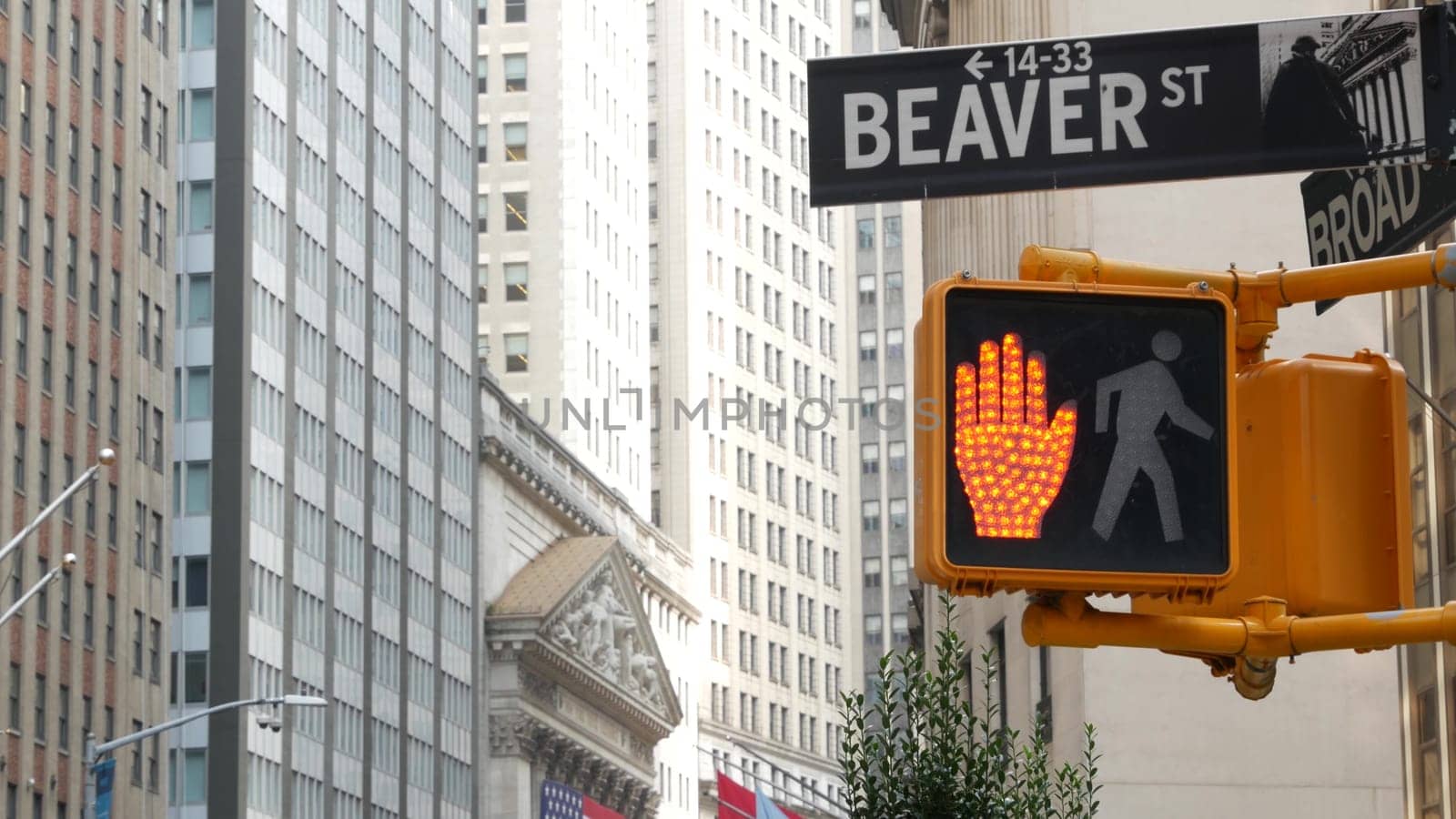 New York City, United States - 9 Sept 2023: Manhattan Downtown Financial District. American flag, Wall street. Broad and Beaver corner road sign. Stock Exchange building, USA Stock Market. Crossroad.