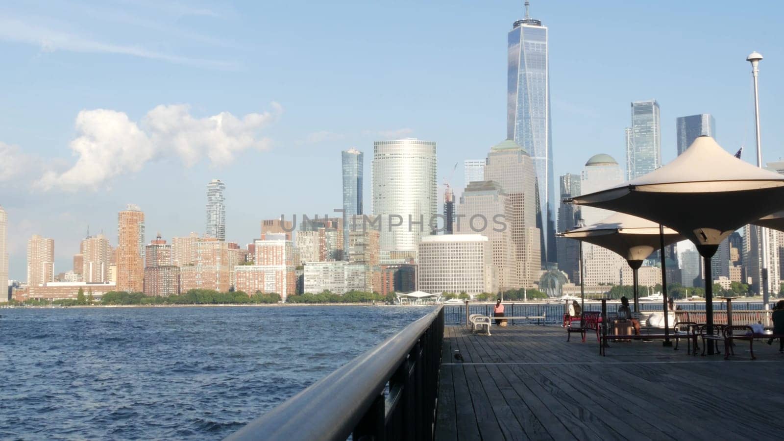 New York City, United States - 12 Sept 2023: Waterfront skyline, Manhattan Downtown Financial district, World Trade Center building, riverfront skyscrapers. From J Owen Grundy Park, New Jersey. People
