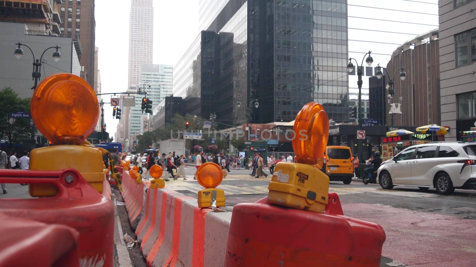 New York City, United States - 29 Aug 2023: Manhattan Midtown 34 street, 8 avenue crossroad intersection. Urban road car traffic in USA. People pedestrians on zebra. Yellow taxi, Empire State building