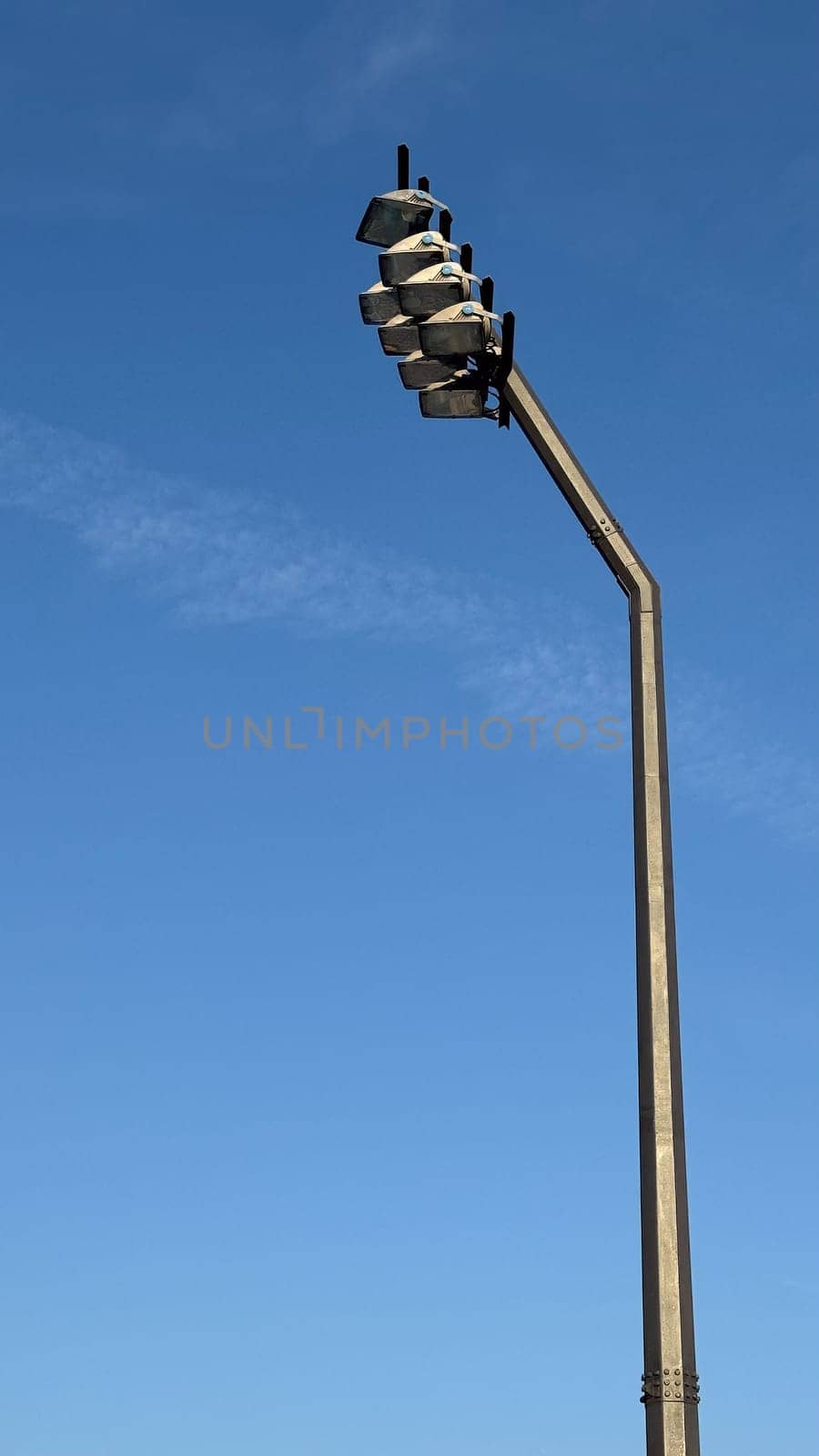 A high stadium floodlight against a clear blue sky. High quality photo