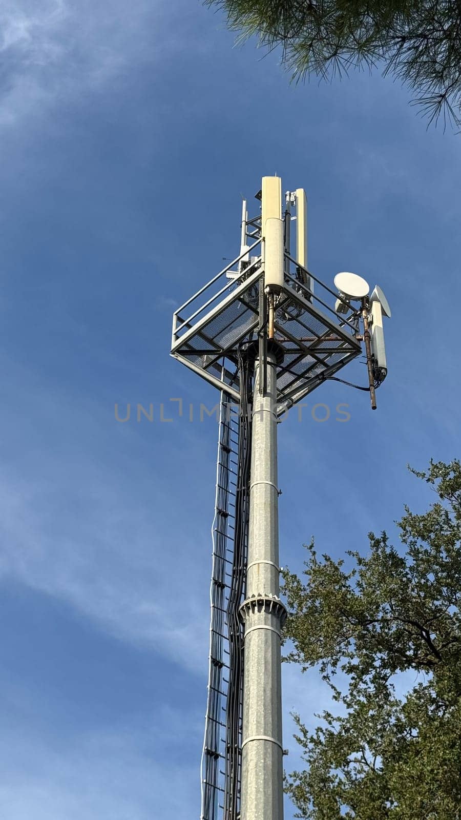 Cell tower with antennas against a blue sky. High quality photos