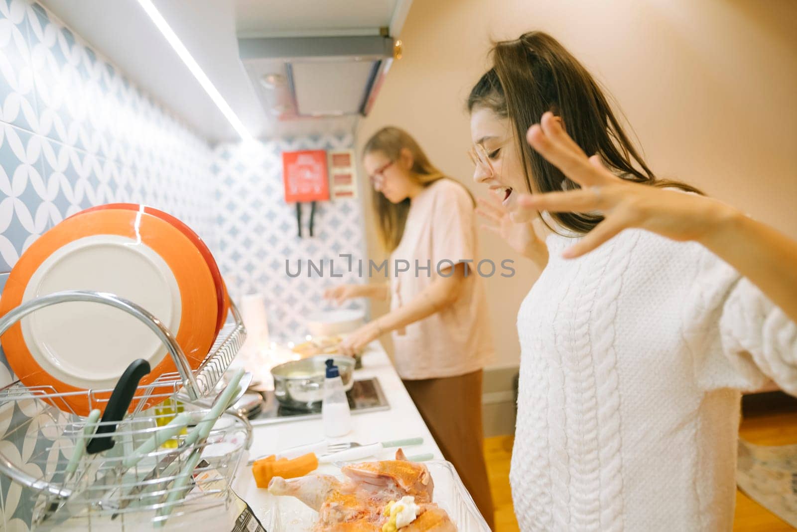 Two close friends sharing a delightful and joyful cooking experience together in a bright and modern kitchen