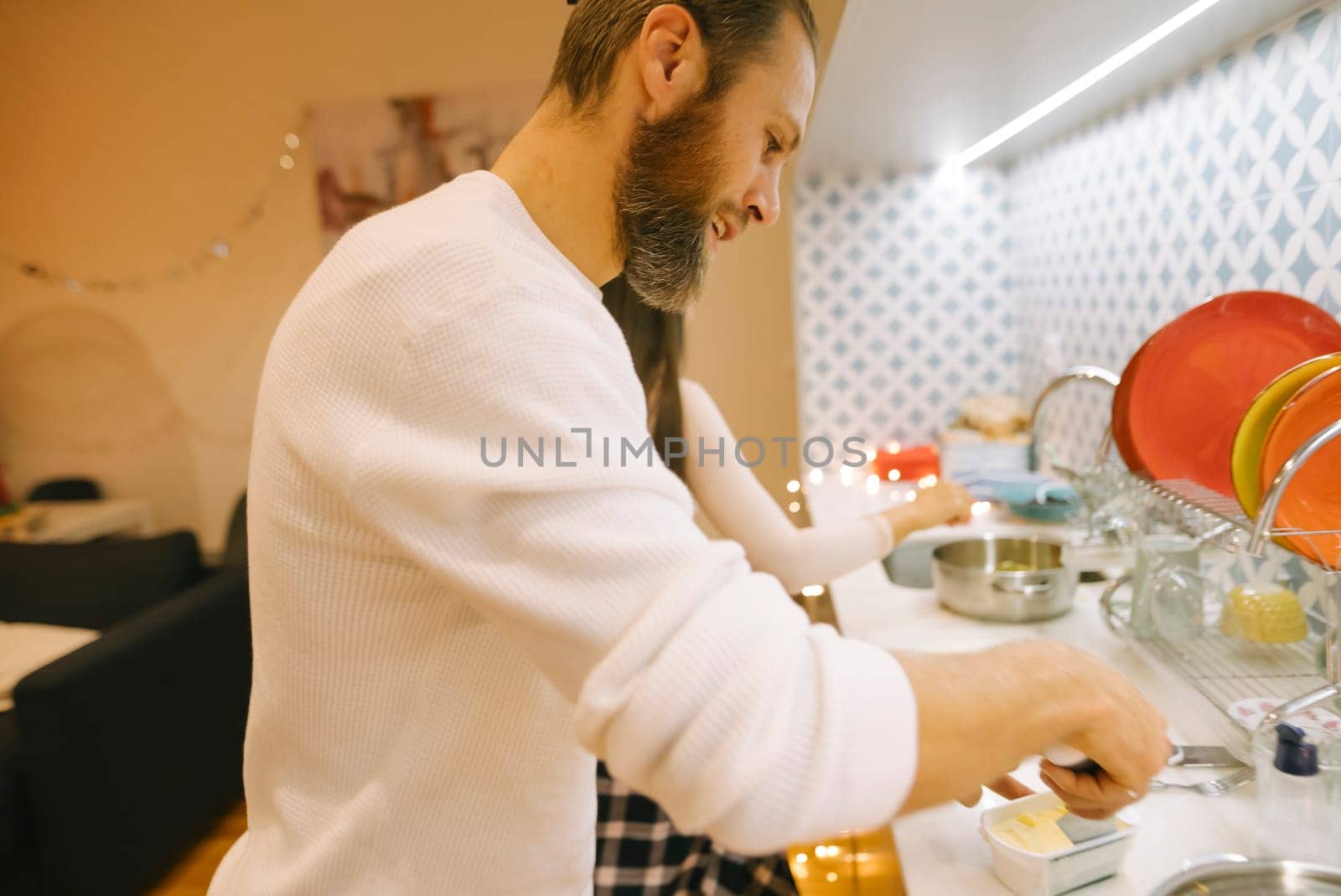 A loving couple shares a delightful experience cooking together in a cozy and warm kitchen space filled with charm