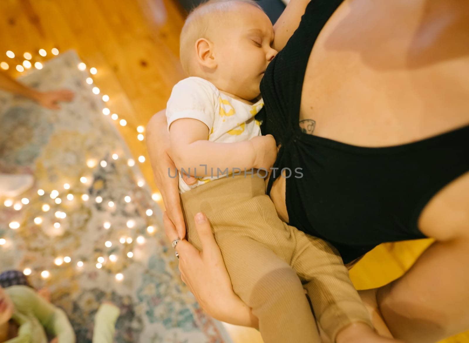 A beautiful tender moment of a mother lovingly breastfeeding her baby indoors, capturing the warmth and love shared