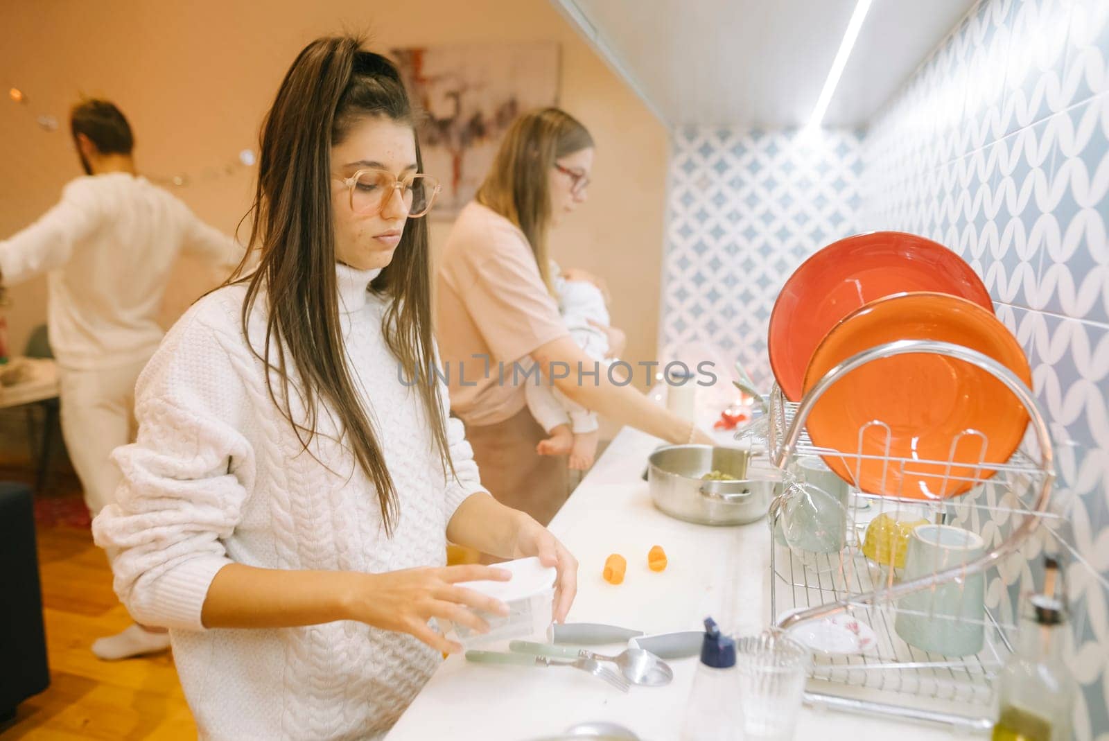 A group of friends enjoying a casual day in the kitchen, washing dishes and sharing great moments together