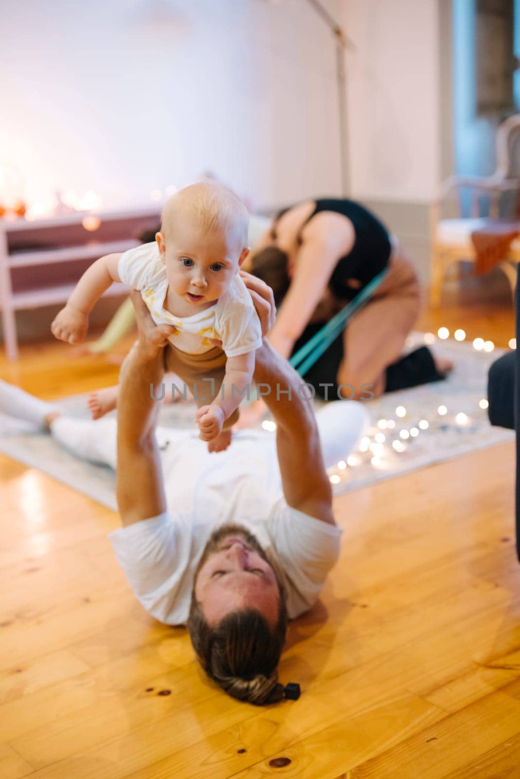 A joyful scene of a parent playing with a baby, showcasing love and connection in a warm atmosphere.